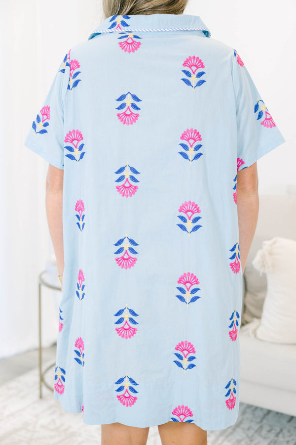 Plus size baby blue shirt dress with magenta floral embroidery, short sleeves, and a flowy fit.