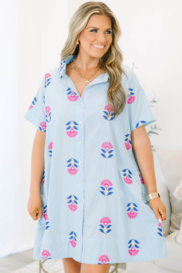Plus size baby blue shirt dress with magenta floral embroidery, short sleeves, and a flowy fit.