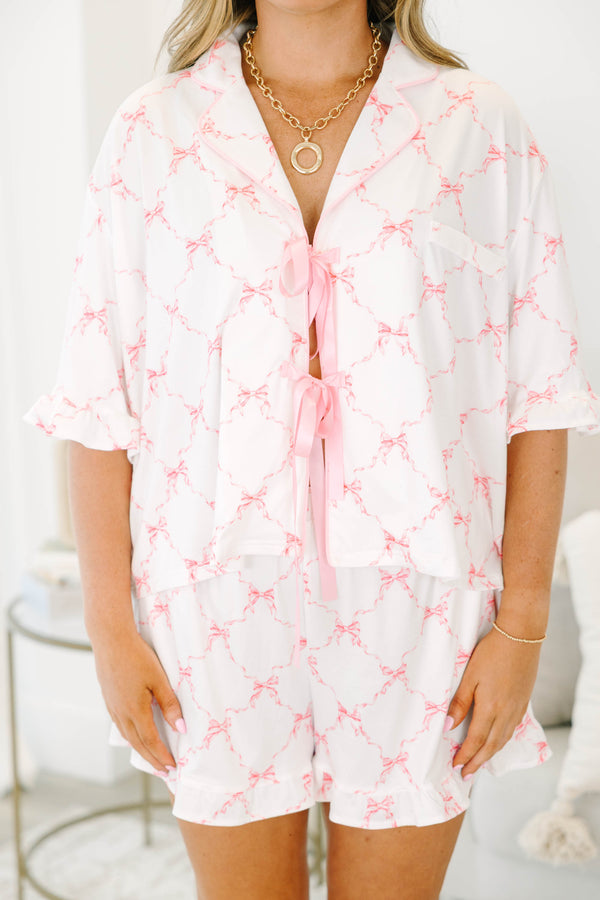 Plus Size white pajama set with pink bow print, featuring a tie-front top and ruffled shorts.