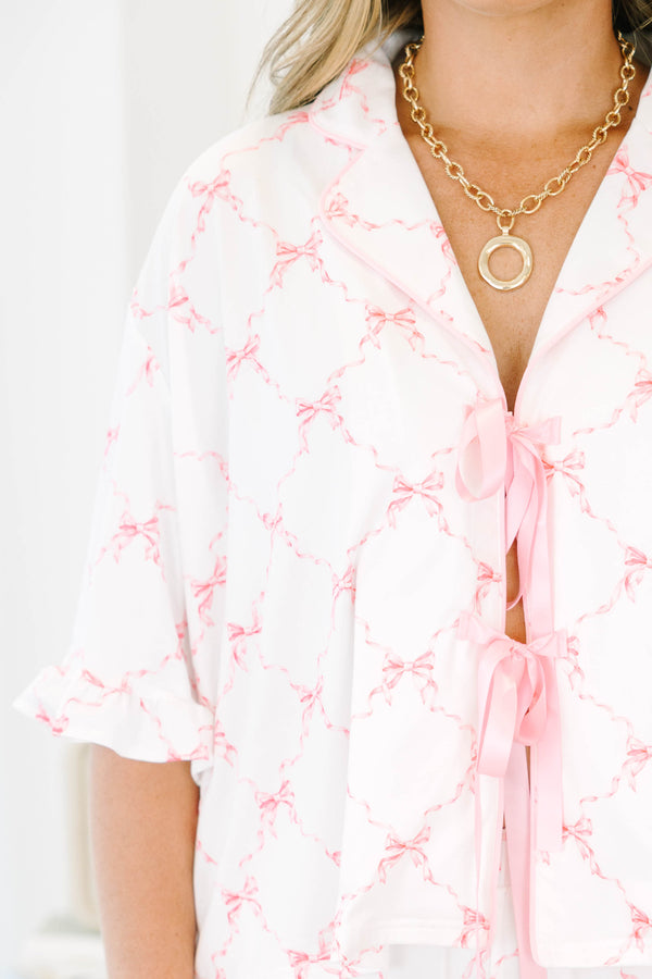 Plus Size white pajama set with pink bow print, featuring a tie-front top and ruffled shorts.