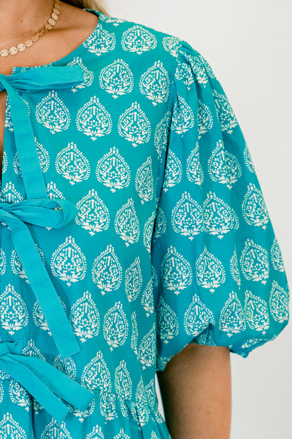 Chic Soul Plus size clothing, bright blue top with bubble sleeves a block pattern and the bows going down the center of the shirt 