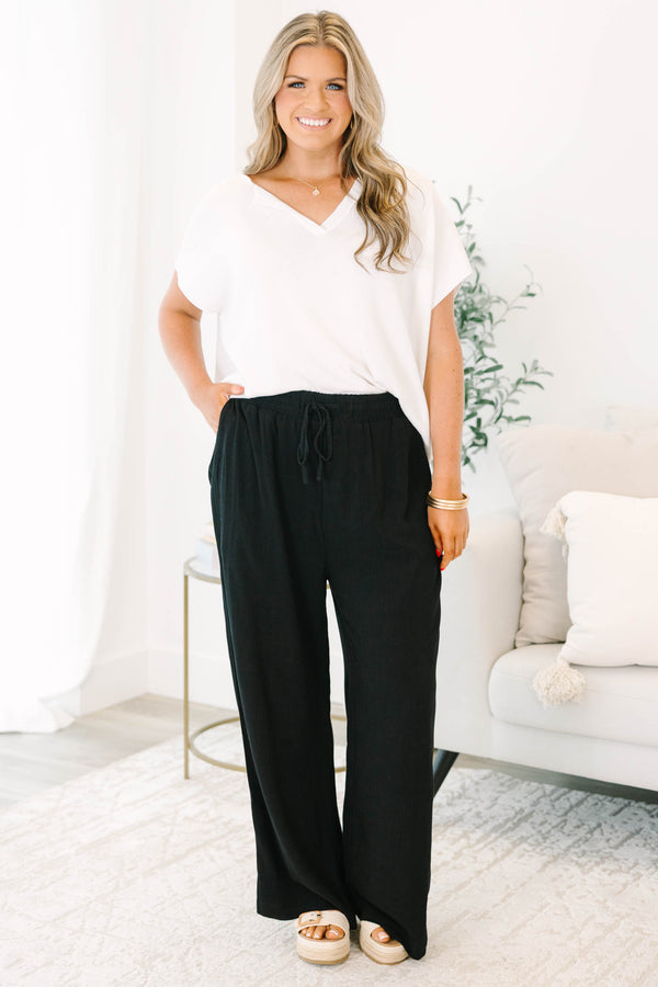 Plus Size black wide-leg pants with an elastic drawstring waistband and a textured fabric.