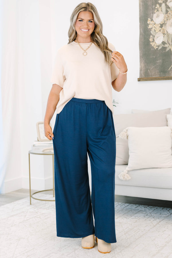Plus size navy flowy palazzo pants with a high-rise elastic waistband in a soft ribbed fabric.