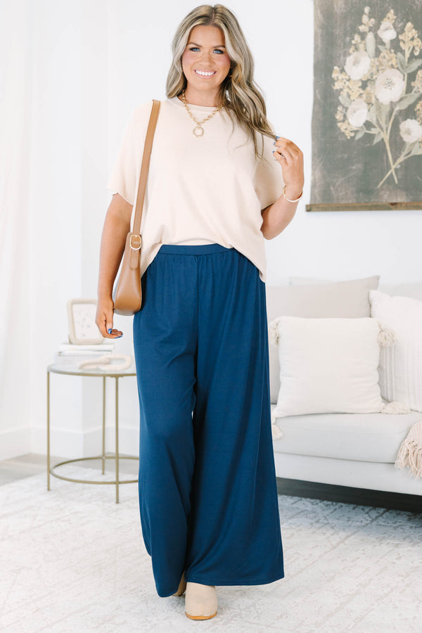 Plus size navy flowy palazzo pants with a high-rise elastic waistband in a soft ribbed fabric.