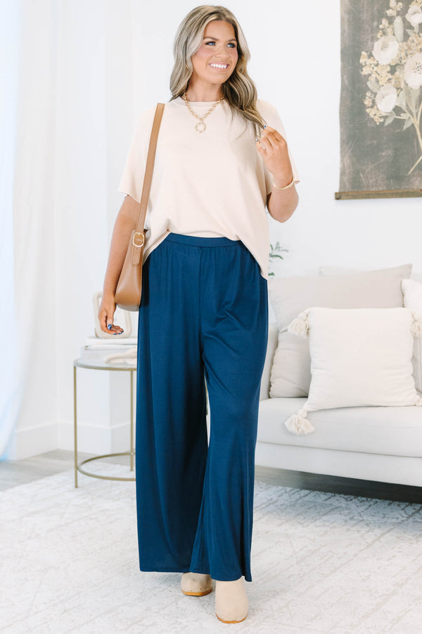 Plus size navy flowy palazzo pants with a high-rise elastic waistband in a soft ribbed fabric.