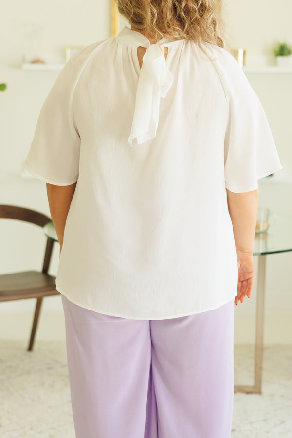 Plus Size white high-neck top with flutter sleeves paired with light purple wide-leg pants.