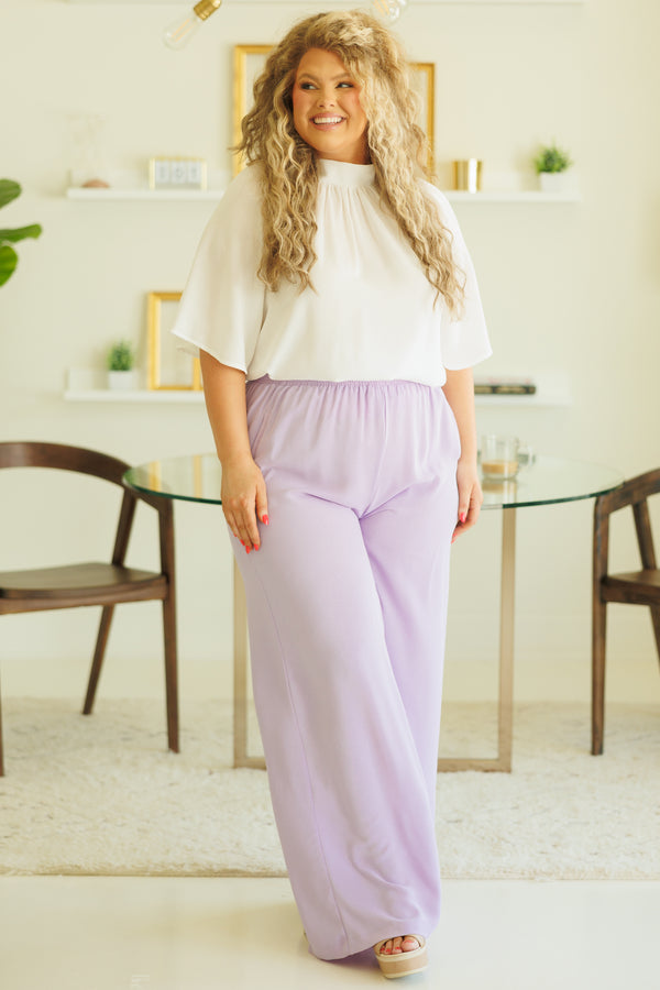 Plus Size white high-neck top with flutter sleeves paired with light purple wide-leg pants.