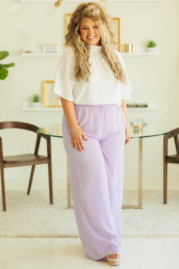 Plus Size white high-neck top with flutter sleeves paired with light purple wide-leg pants.