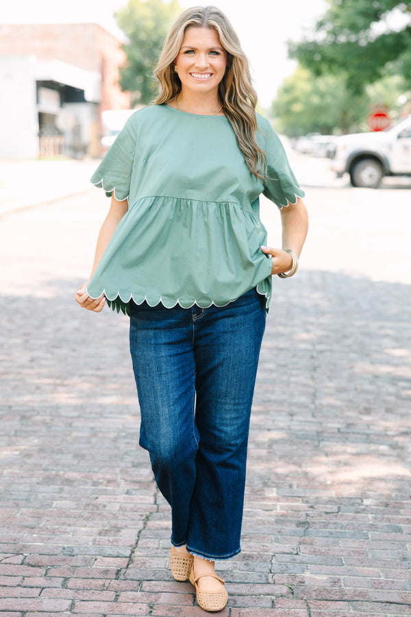 Plus Size olive babydoll top with white scalloped trim on the sleeves and hem.