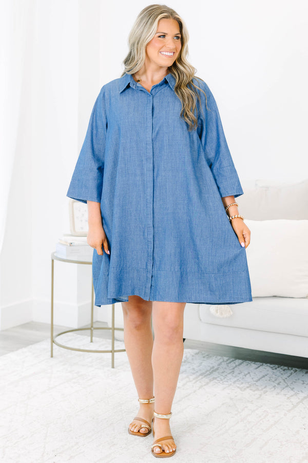 Plus size blue chambray shirt dress with a flowy fit, button placket, and three-quarter sleeves.