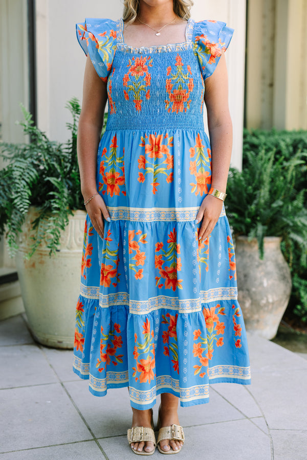 Plus Size blue tiered maxi dress with orange floral print, smocked bodice, and flutter sleeves.