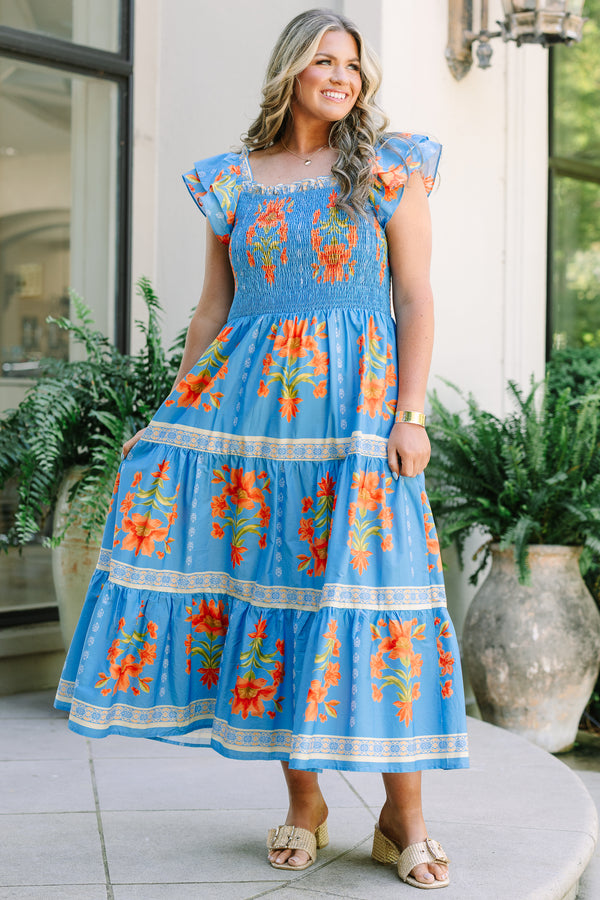 Plus Size blue tiered maxi dress with orange floral print, smocked bodice, and flutter sleeves.