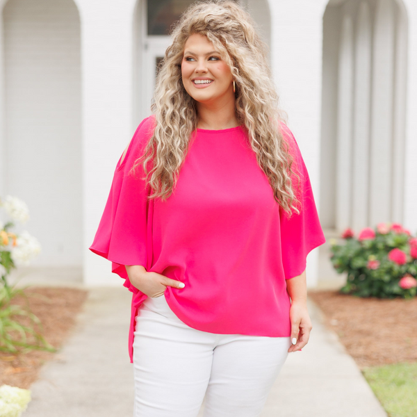 Plus Size hot pink flowy top with cold shoulder sleeves and white denim pants.
