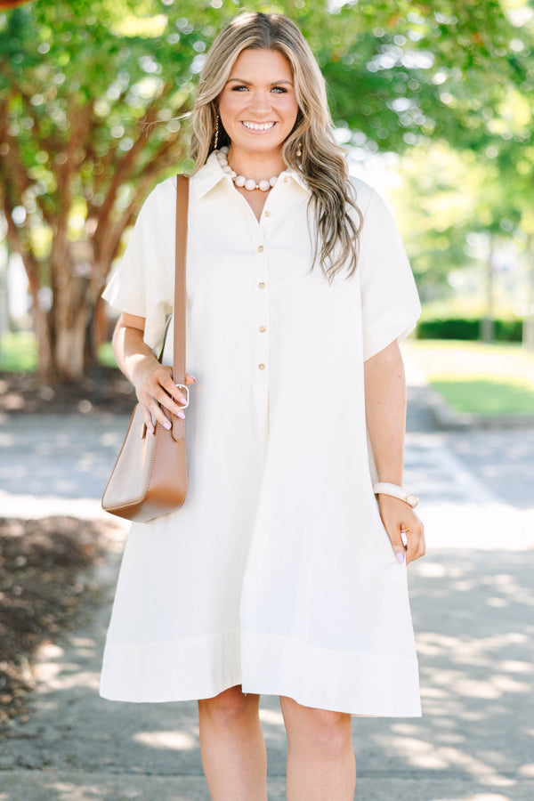 Plus size cream A-line shirt dress with a collared neckline, functional buttons, and short sleeves.