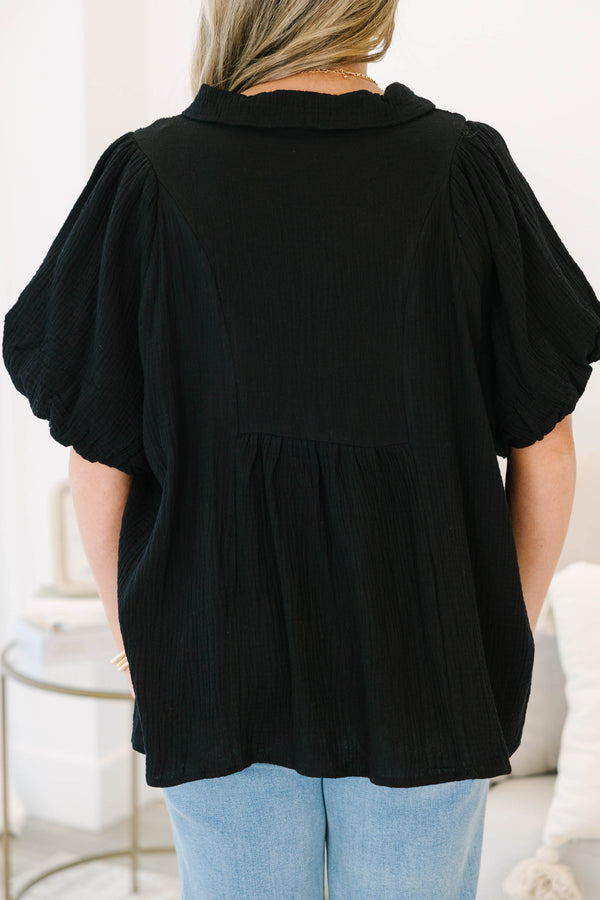 Plus size black cotton top with a flowy fit, smocked bodice, and puff sleeves.