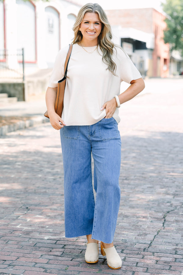 Plus Size medium wash wide leg cropped jeans with front patch pockets and a frayed hemline.