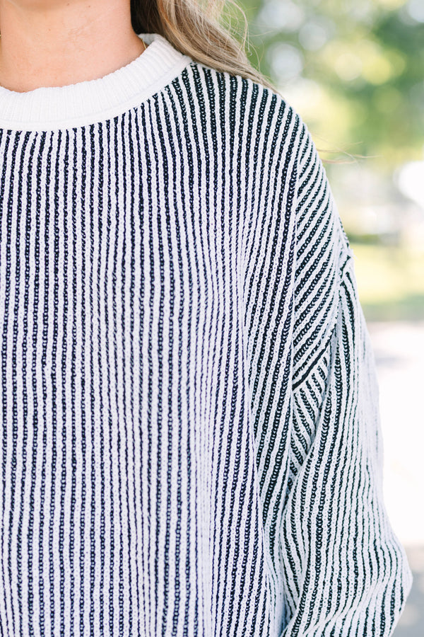 Plus Size oversized black and white vertical striped knit sweater with a crew neck and ribbed trim.