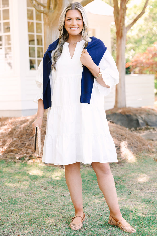 Plus Size white babydoll dress with a split v-neck, smocked cuffs, and mini bell sleeves.
