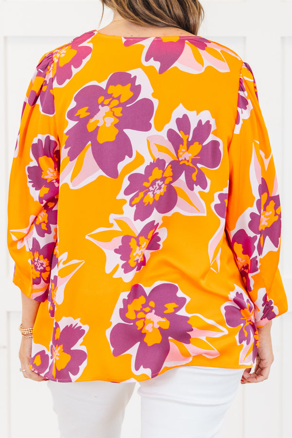 Plus Size orange V-neck top with a bold purple and pink floral print and long sleeves.