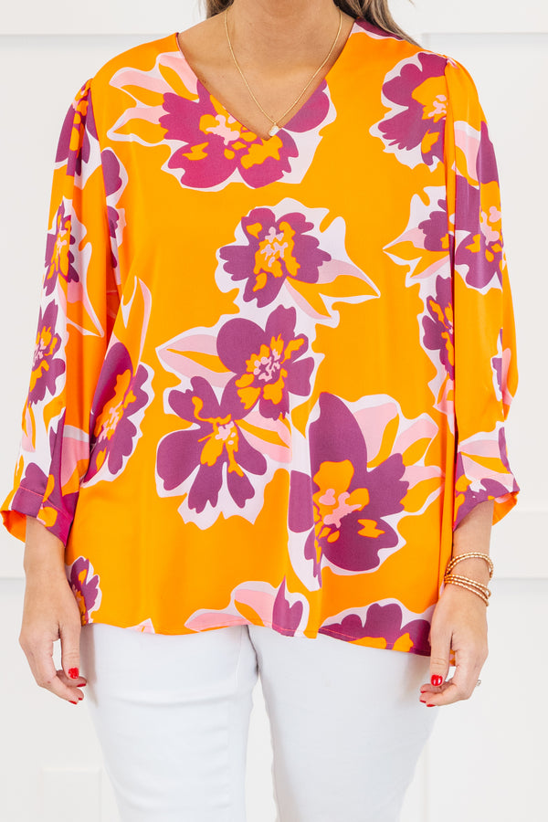 Plus Size orange V-neck top with a bold purple and pink floral print and long sleeves.