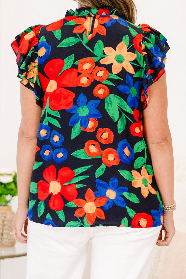 Plus Size navy floral top with flutter sleeves, a ruffled neckline, and colorful flower patterns.