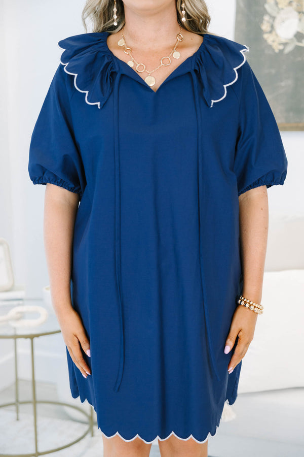 Navy blue mini dress features a scalloped collar with white trim and a matching scalloped hemline