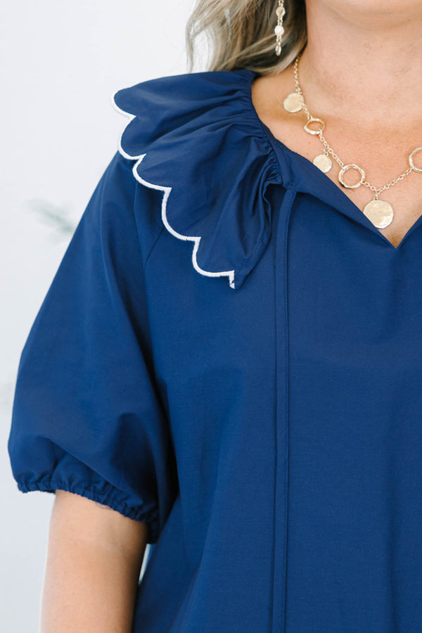 Navy blue mini dress features a scalloped collar with white trim and a matching scalloped hemline