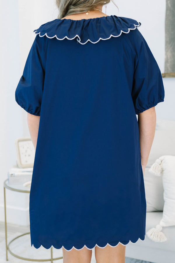 Navy blue mini dress features a scalloped collar with white trim and a matching scalloped hemline