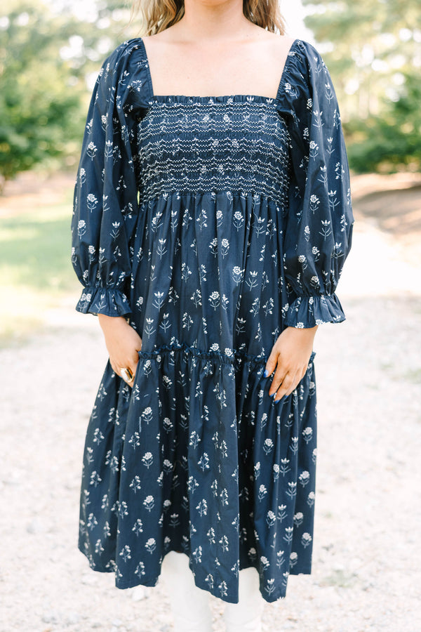 Plus Size black floral midi dress with a smocked bodice, square neckline, and long puff sleeves.