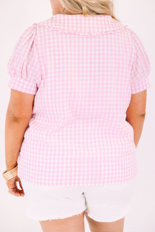 Chic Soul plus size clothing, pink button up top with short sleeves that have cuffs at the end of the sleeves as well as a bib detail on the shoulders that has ruffle detailing and a pink gingham pattern throughout 
