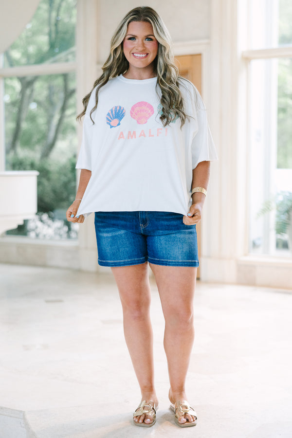 Plus Size white vintage wash tee with three colorful seashells and Amalfi text, paired with denim.