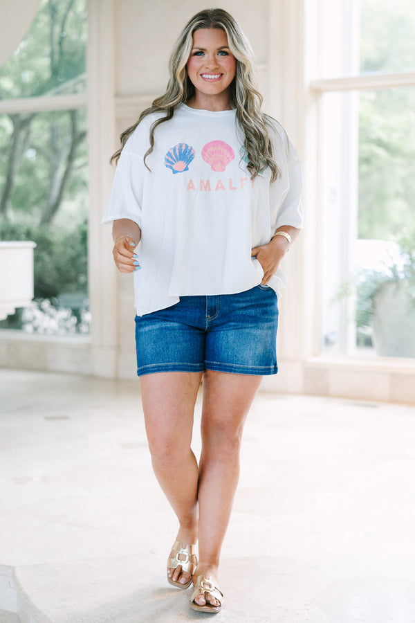 Plus Size white vintage wash tee with three colorful seashells and Amalfi text, paired with denim.
