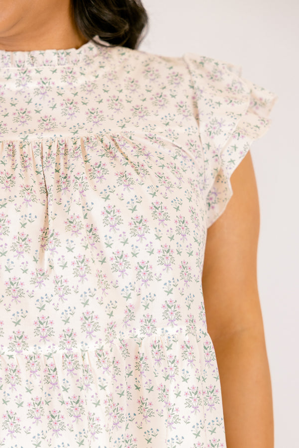 Chic Soul plus size clothing, cream top with flutter sleeves and a high neck that has ruffle detailing on the neckline of the top as well as a light floral pattern throughout the top 