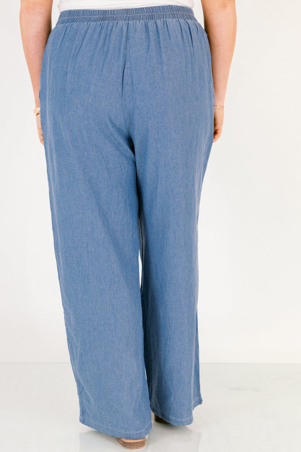 Chic Soul plus size clothing, medium wash denim blue straight leg flowy pants with white embroidery detailing on the ankles and white drawstring tassel tie at the waist