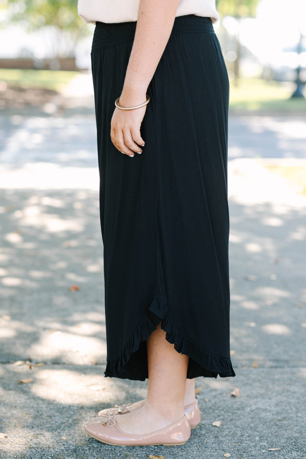 Plus Size black wide-leg rayon pants with a smocked waistband and ruffled hem.