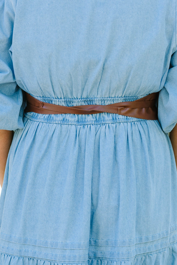 Plus Size brown faux leather wrap belt tied in a bow over a light blue denim dress.