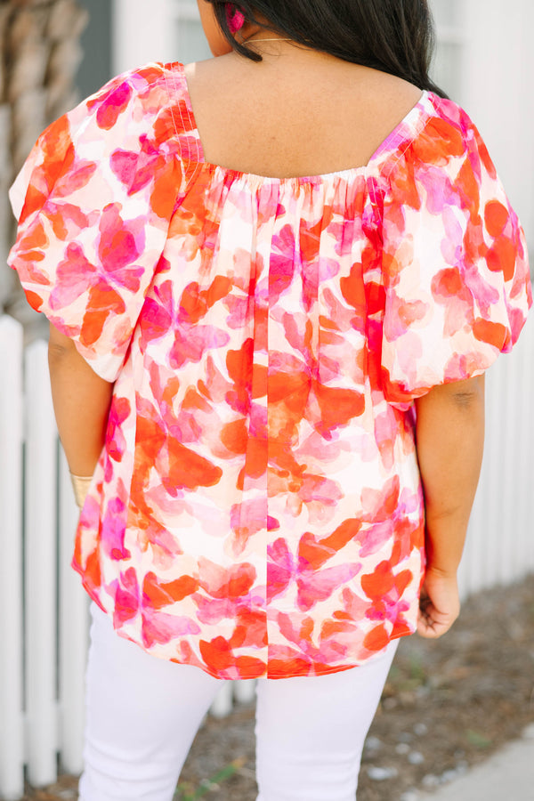 Chic Soul plus size clothing, white top with bubble sleeves a square neckline and a pink and orange and red watercolor floral pattern throughout