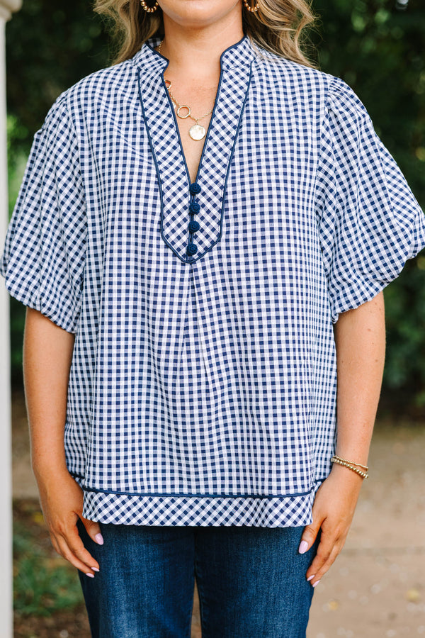 Plus size navy gingham top with a flowy fit, V-neckline, and short flutter sleeves.