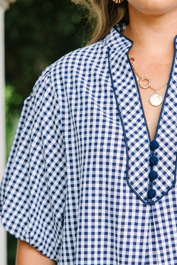 Plus size navy gingham top with a flowy fit, V-neckline, and short flutter sleeves.