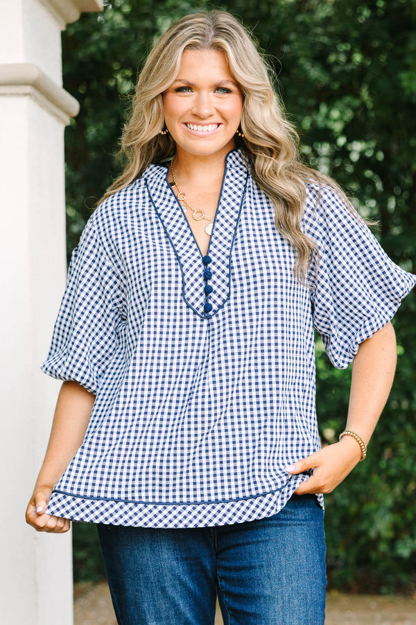 Plus size navy gingham top with a flowy fit, V-neckline, and short flutter sleeves.
