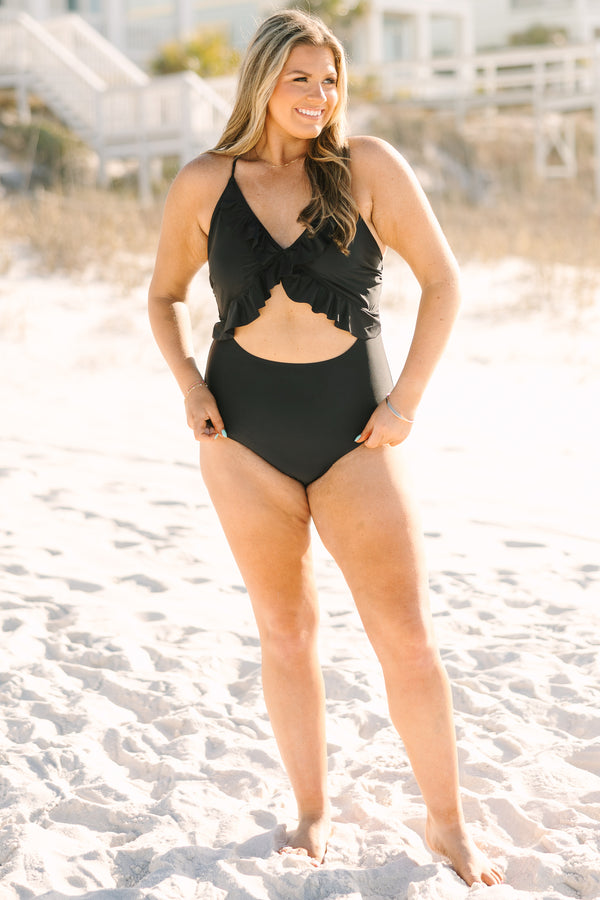 Plus Size black one-piece swimsuit with a front cutout, ruffle trim, and adjustable corset back.