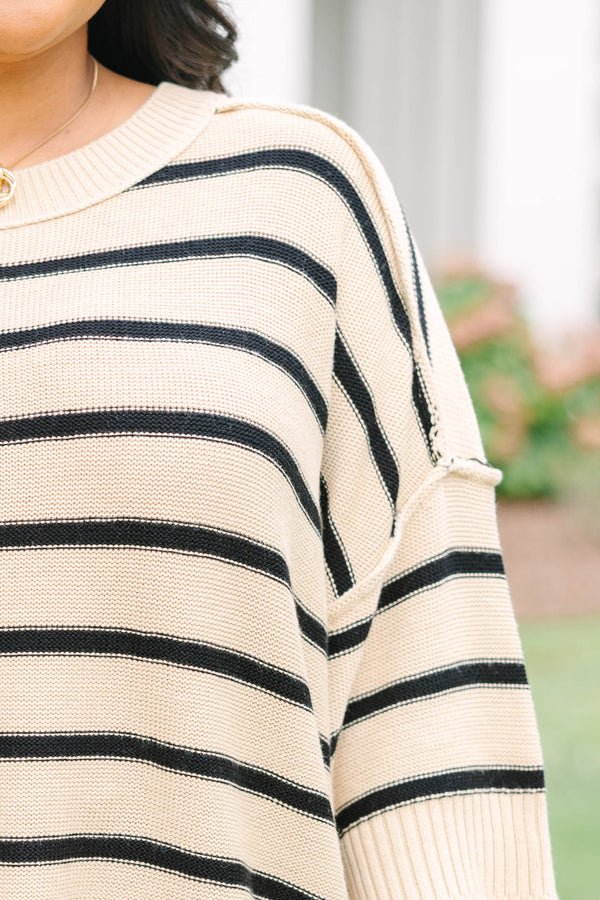taupe sweater with drop shoulders and black stripes with exposed seam details