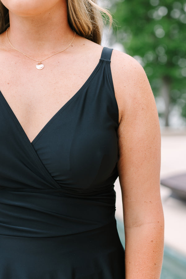 Black Swim Dress with a flowy skirt, wrap-style bodice, and adjustable straps.