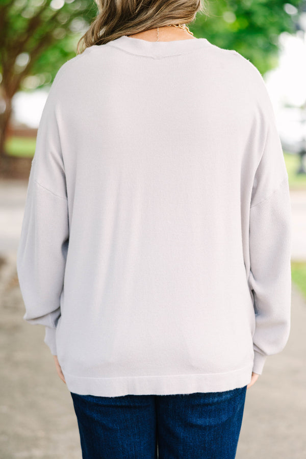 Plus size taupe-gray V-neck sweater with a relaxed, flowy fit and soft, stretchy fabric.