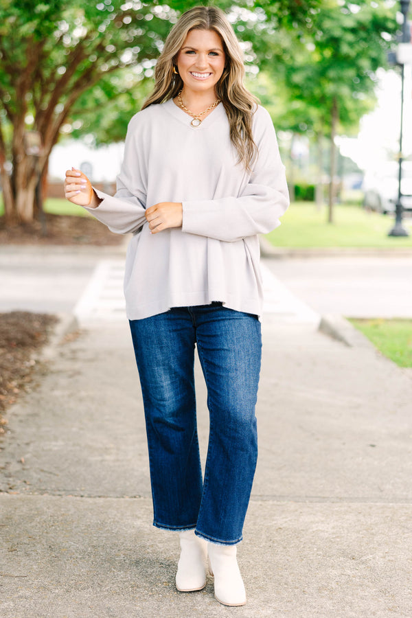 Plus size taupe-gray V-neck sweater with a relaxed, flowy fit and soft, stretchy fabric.