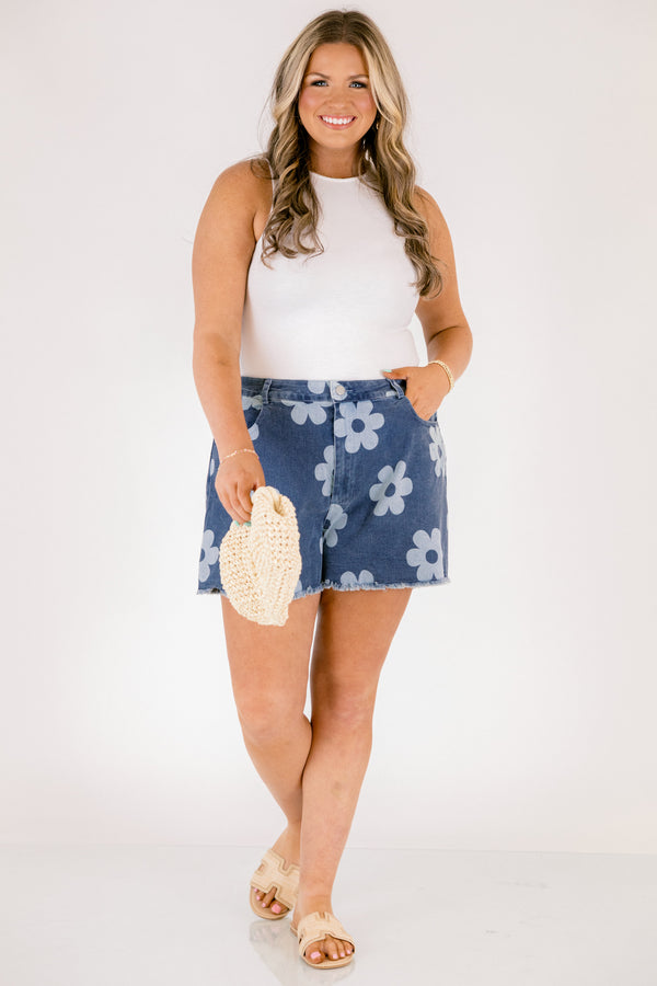Chic Soul plus size clothing, dark denim shorts with front pockets and fringe details at the end of the shorts and a light blue floral pattern throughout