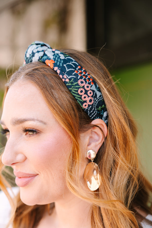 Chic Soul plus size clothing, black headband with a knot detail on the top of the headband and a multi color floral pattern throughout the headband 