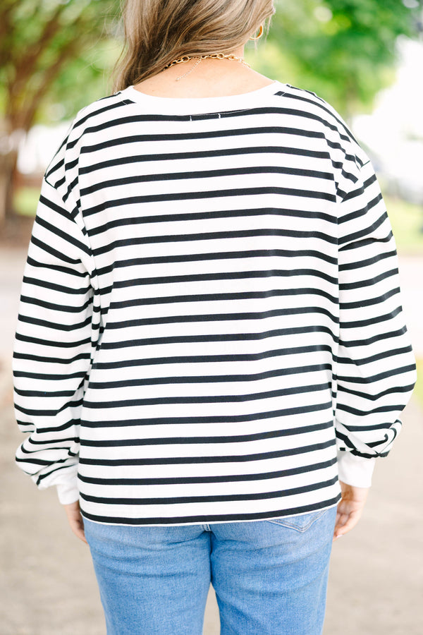Plus size woman in a flowy white and black striped long sleeve cotton top with a front pocket.