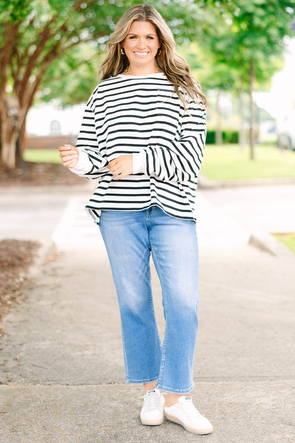 Plus size woman in a flowy white and black striped long sleeve cotton top with a front pocket.