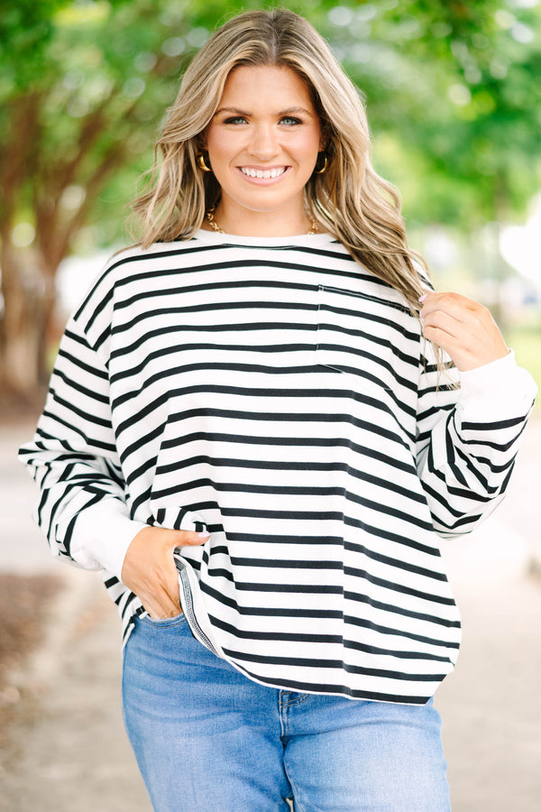 Plus size woman in a flowy white and black striped long sleeve cotton top with a front pocket.